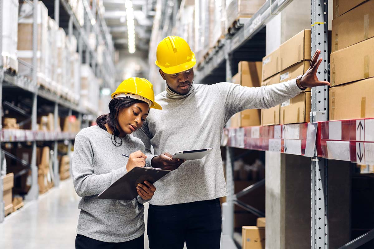 Two engineers checking goods in a warehouse