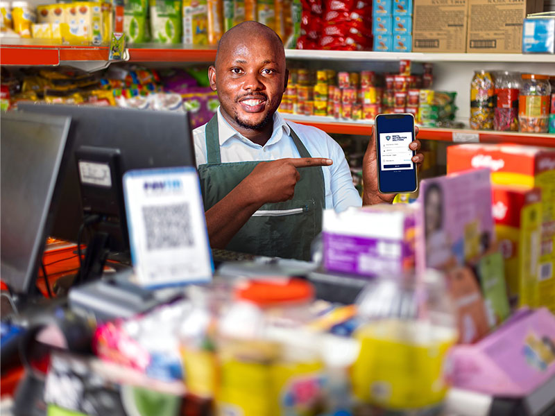 Male shop attendant holding a mobile device