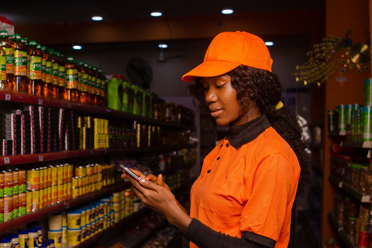 Female shop attendant using her mobile phone