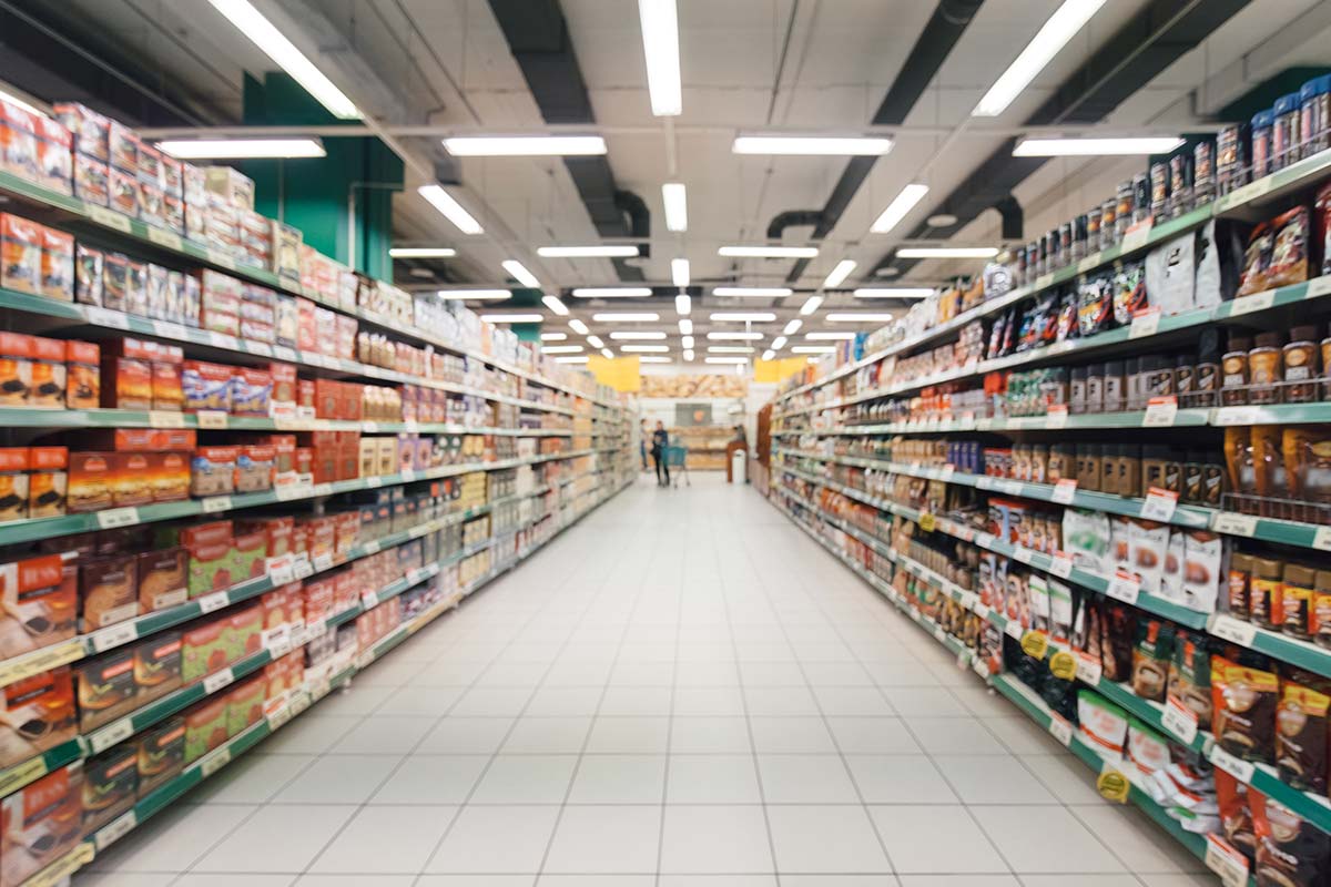 Interior view of a supermarket with stocked aisles